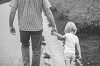 Grandpa holding grandchild's hand as they go for a walk